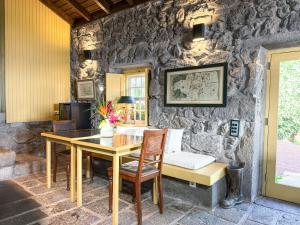 a dining room with a table and a stone wall at Quinta das Buganvílias in Castelo Branco