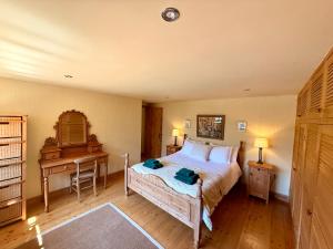 a bedroom with a bed and a desk at Meadow Cottage in Fowey