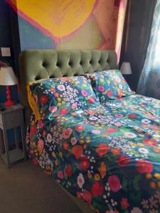 a bed with a floral comforter on it with a bedskirts at Sailaway in Carbis Bay