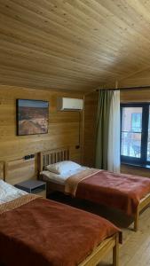 a bedroom with two beds in a wooden cabin at Kolsay Eco House in Saty +33 photos