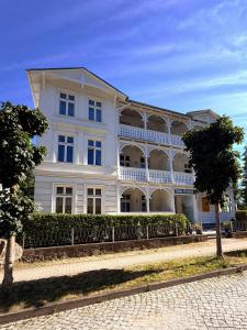 a large white building with a fence in front of it at Villa Victoria in Binz