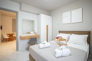 a bedroom with a bed with towels on it at Agora Luxury Suites in Lixouri