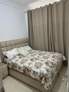 a bed with a floral comforter in a bedroom at Nadrs in Tangier