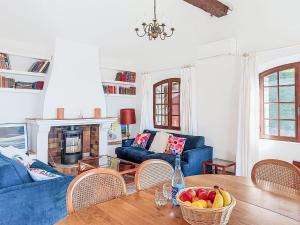 a living room with a table and a blue couch at Villa Balcon d'Azur by Interhome in Spéracèdes