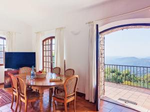 a dining room with a table and chairs and a balcony at Villa Balcon d'Azur by Interhome in Spéracèdes
