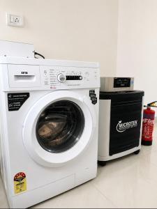 a white washing machine sitting next to a microwave at Serenity Casa II in Varca