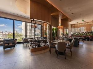 a restaurant with tables and chairs in a building at Mercure Antalya Konyaalti in Antalya