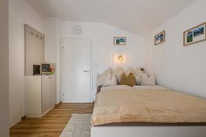 a white bedroom with a large bed in it at Alpenplatzl XS in Bad Hofgastein