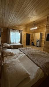 a large bedroom with two large beds in it at Kolsay Eco House in Saty