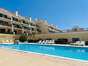 a swimming pool in front of a large building at Ericeira Beach House in Ericeira