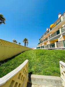 a grassy area with a building in the background at Ericeira Beach House in Ericeira