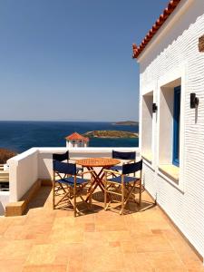 a patio with a table and chairs on a balcony at Andros Villa in Andros +42 photos