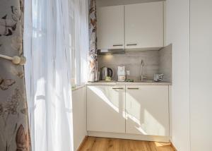 a kitchen with white cabinets and a sink at Alpenplatzl XS in Bad Hofgastein