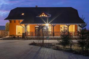 a house with a black roof with the light on at Wellez Vendégház in Sajóvelezd