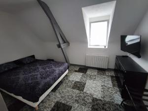 a bedroom with a bed and a flat screen tv at Domaine Sylvaria in Lassay-sur-Croisne