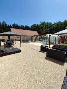 a patio with tables and chairs and a building at Domaine Sylvaria in Lassay-sur-Croisne