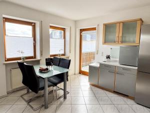 a kitchen with a table and some chairs and a counter at Ferienwohnung Weiher - Nähe Nürnberg / Messe in Schwanstetten