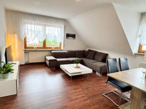 a living room with a couch and a table at Ferienwohnung Weiher - Nähe Nürnberg / Messe in Schwanstetten