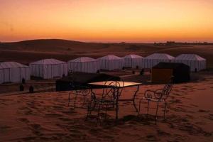a group of tables and chairs in the desert at Sahara Starlight camp in Merzouga