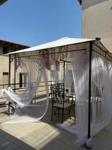 a gazebo with white curtains and tables and chairs at Rooms Vincanto in Salsomaggiore Terme