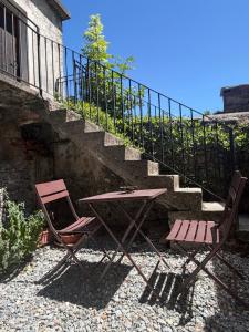 two folding chairs and a table and a staircase at Maison Berthod in Aosta