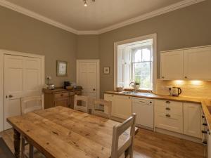 a kitchen with a wooden table and a dining room at Apartment Macduff Tower by Interhome in Angus +7 photos