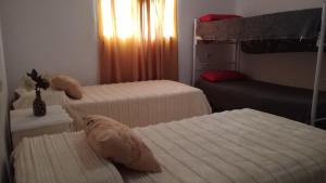 a bedroom with two beds and a bunk bed at La casa de Piscis in Termas de Río Hondo