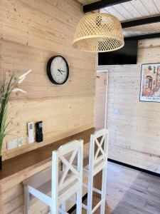 a room with two chairs and a clock on the wall at Domek Słoneczna in Mieroszyno