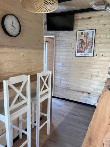 a room with two stools and a clock on the wall at Domek Słoneczna in Mieroszyno