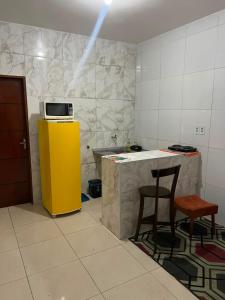 a kitchen with a yellow refrigerator and a table and chairs at Villa do mar Praia de Iracema in Fortaleza