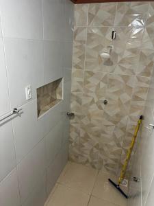 a bathroom with a shower with a tiled wall at Villa do mar Praia de Iracema in Fortaleza