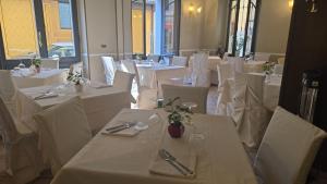 a dining room with white tables and white chairs at Rooms Vincanto in Salsomaggiore Terme