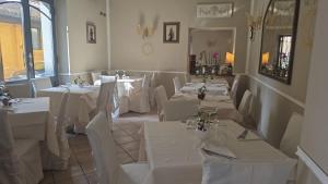 a dining room with white tables and white chairs at Rooms Vincanto in Salsomaggiore Terme