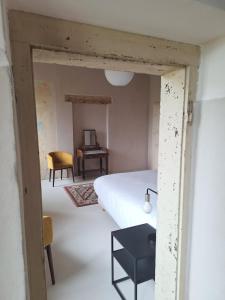 a bedroom with a white bed and a desk at DIMORA STORICA ZACCHI D'ARRIGO in Belluno