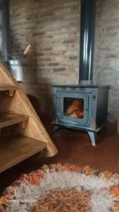 a wood fired oven in a room with a rug at La Agraria in Junín