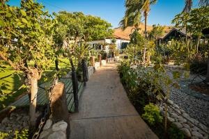 a path in a garden with trees and a fence at סוויטות חלב ודבש in Kefar Zetim