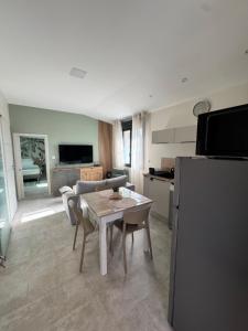 a kitchen and living room with a table and a refrigerator at Les Iles d'ici in Rochefort