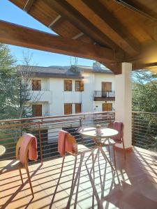 a patio with a table and chairs on a balcony at Maria Luisa Mountain Lodge in Rovere
