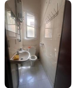 a white bathroom with a sink and a toilet at Le coin vert in Rabat