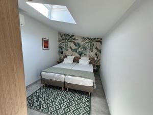 a bedroom with a bed and a skylight at Les Iles d'ici in Rochefort