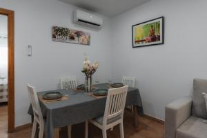 a dining room with a table and chairs and a couch at Casa del sol Armilla in Armilla