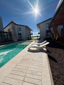 a pool with a row of seats next to a building at Apart Ogaraity Hotel in Goya