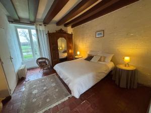 a bedroom with a bed and a large window at Manoir de la Blonnerie in Vellèches