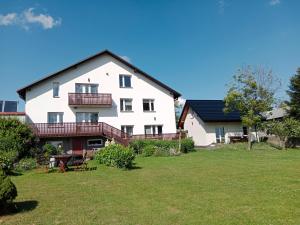 a large white house with a yard at Agroturystyka u Basi in Wola Kalinowska
