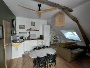 a kitchen and living room with a table and a couch at Le logis d'Emerance in La Pouëze