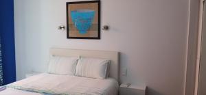 a bedroom with a bed and a picture on the wall at Le chat bleu in Beauvoir-sur-Mer