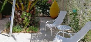 a couple of chairs and a table and a yellow container at Le chat bleu in Beauvoir-sur-Mer