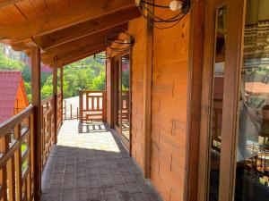 a porch of a wooden house with a glass door at Embellupe Breakfast included in San Jose del Pacifico