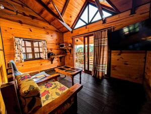a living room with a couch and a tv in a cabin at Embellupe Breakfast included in San Jose del Pacifico