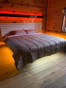 a bedroom with a large bed in a wooden room at Embellupe Breakfast included in San Jose del Pacifico